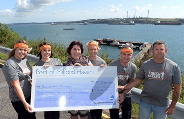 The Port of Milford Haven’s ‘Muddy Rudders’ team present a cheque to Judith Williams from the Paul Sartori Foundation