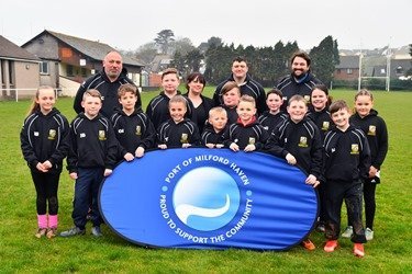 : Emma Hutchings, PR and Communications Assistant at the Port, with members of Pembroke Dock RFC Under 9’s team in their new tour hoodies